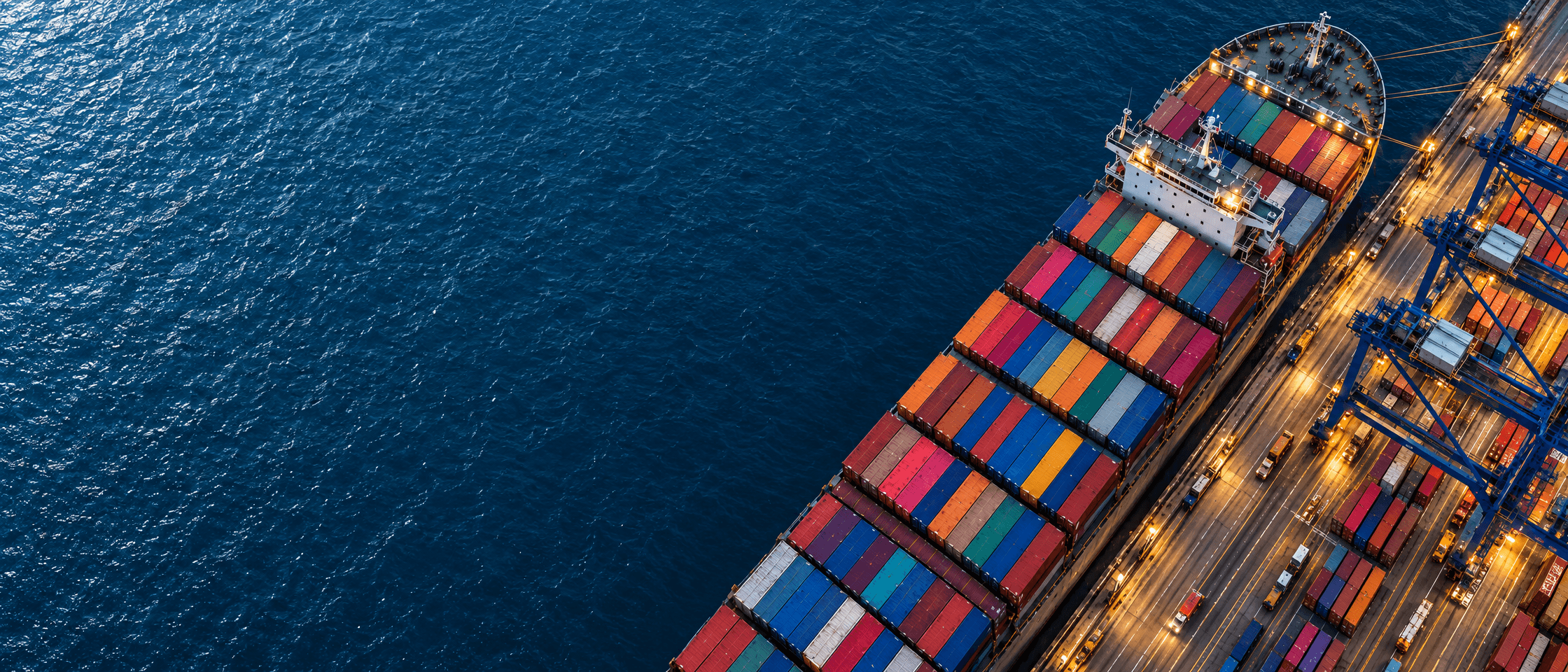 Containerschip aan een verlichte terminal, van boven gezien
